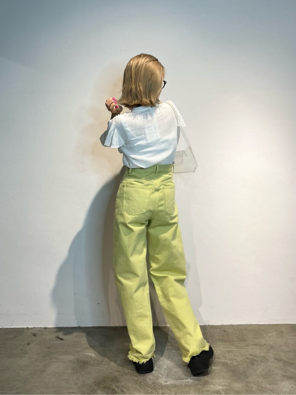 ホワイト系のキャミソール、イエロー系のデニムパンツ、ホワイト系のシャツ/ブラウスを着用したレディースの春コーディネートの3枚目の写真