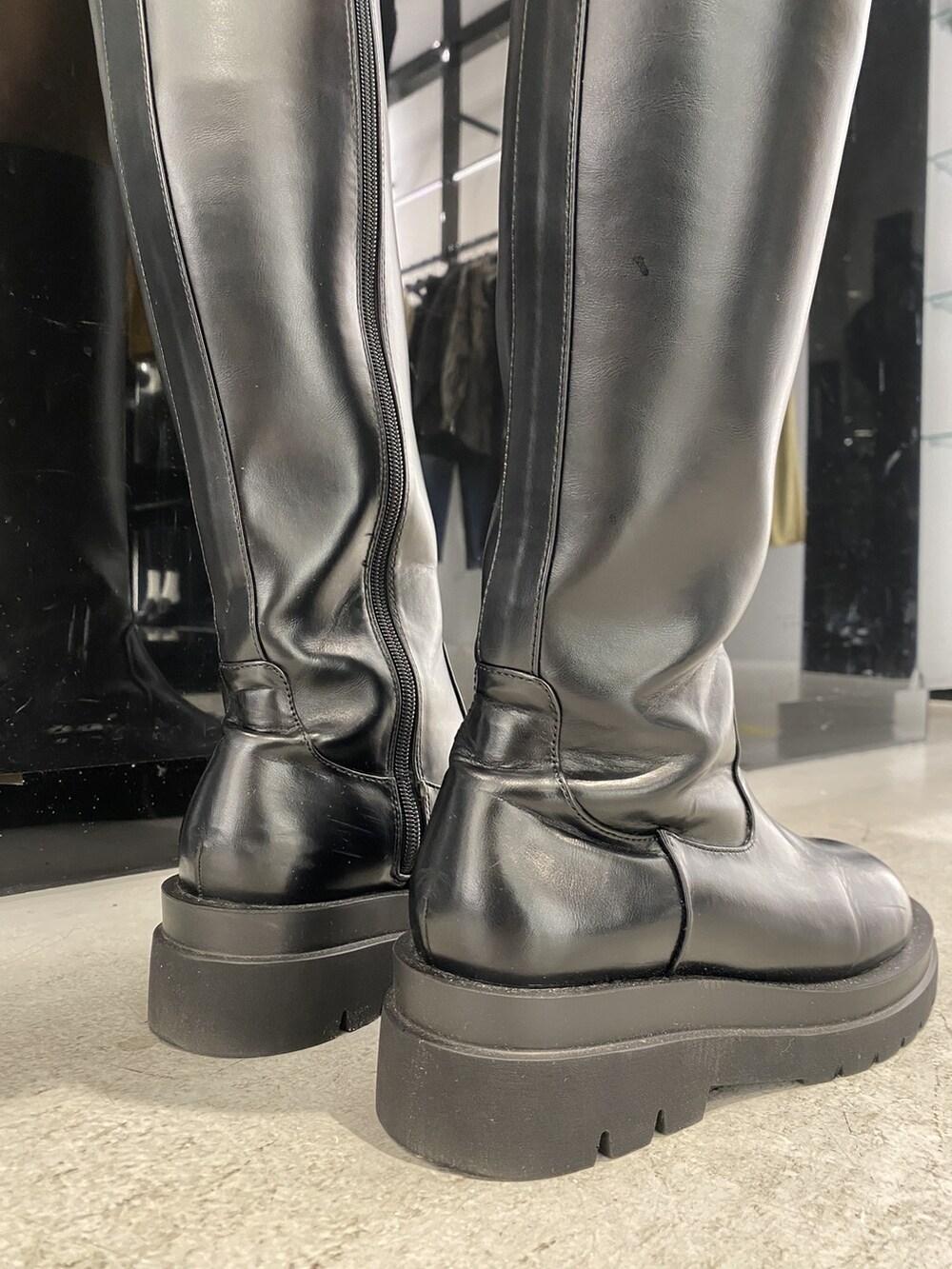 ホワイト系のニット/セーター、グレー系のトレンチコート、ブラック系のブーツを着用したレディースの秋コーディネートの6枚目の写真