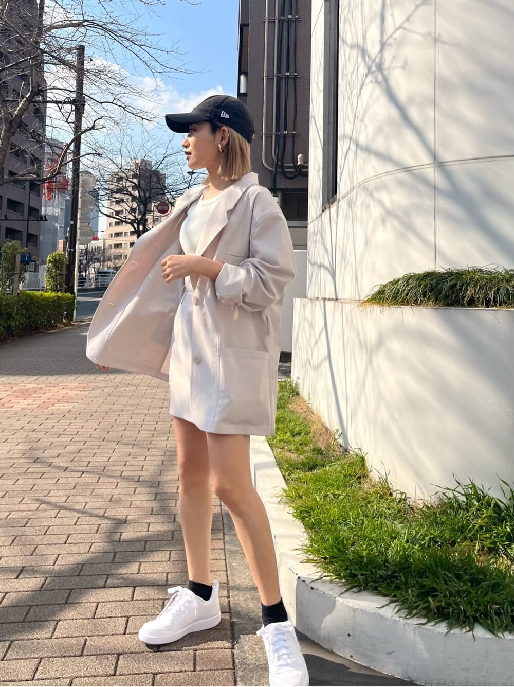 ホワイト系のテーラードジャケット、ホワイト系のスカートを着用したレディースの春コーディネートの2枚目の写真