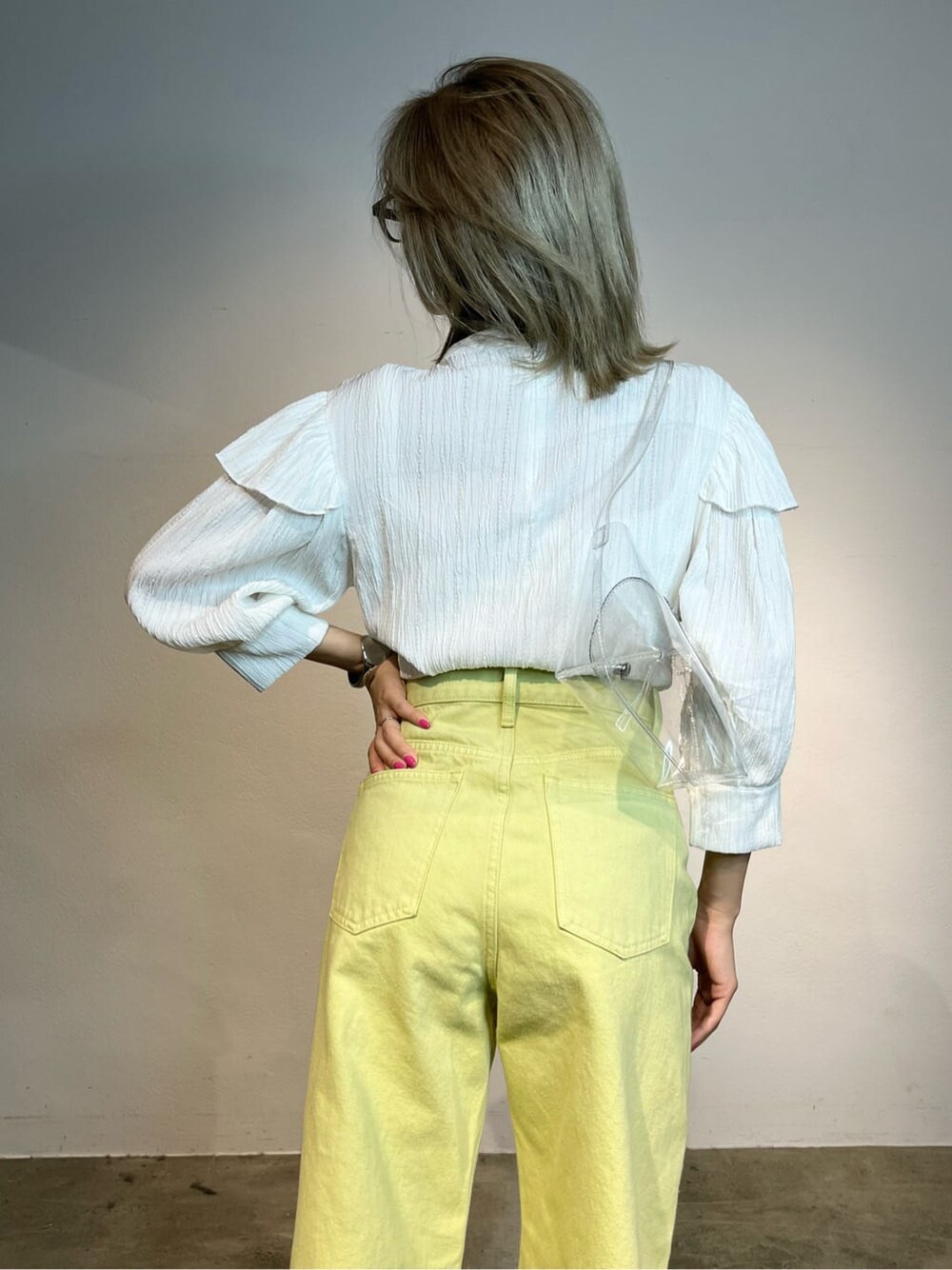 ホワイト系のキャミソール、イエロー系のデニムパンツ、ホワイト系のシャツ/ブラウスを着用したレディースの春コーディネートの4枚目の写真