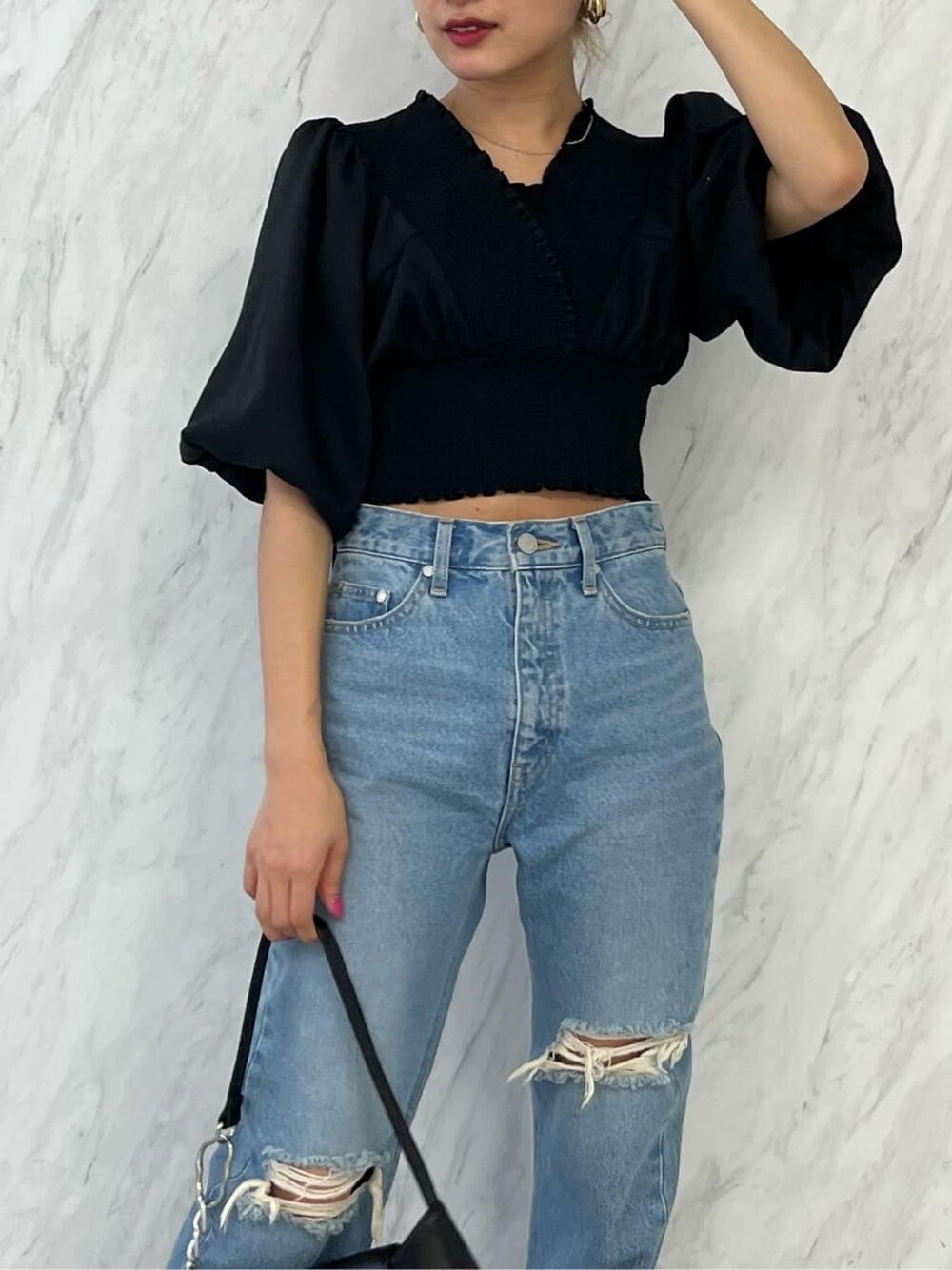 ブラック系のシャツ/ブラウス、ブラック系のハンドバッグ、ブルー系のデニムパンツを着用したレディースの春コーディネートの6枚目の写真