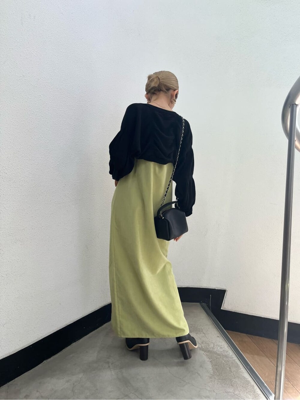 ブラック系のブーツ、ブラック系のニット/セーター、イエロー系のワンピースを着用したレディースの春コーディネートの4枚目の写真