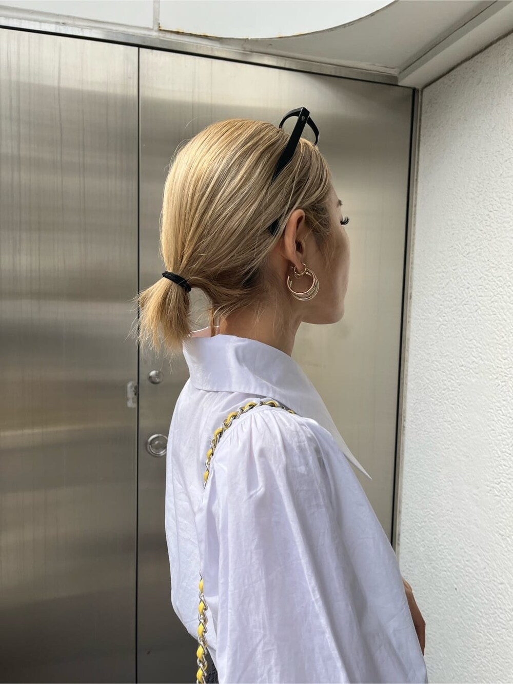 ブラック系のその他パンツ、イエロー系のショルダーバッグ、ホワイト系のシャツ/ブラウスを着用したレディースの春コーディネートの6枚目の写真