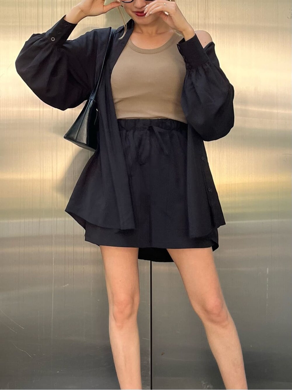 ブラック系のハンドバッグ、ベージュ系のタンクトップ、ブラック系のその他パンツを着用したレディースの夏コーディネートの5枚目の写真