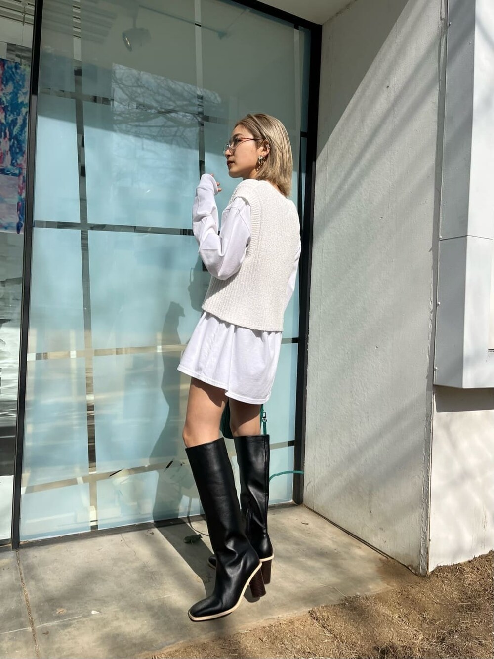 ブラック系のブーツ、ホワイト系のTシャツ/カットソー、ブルー系のショルダーバッグを着用したレディースの春コーディネートの2枚目の写真