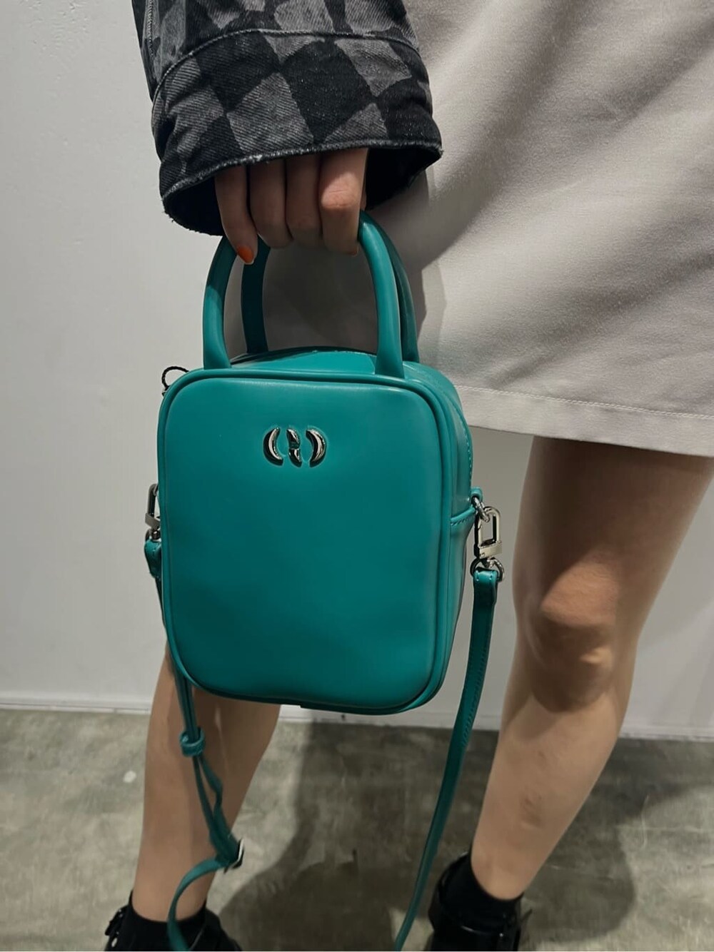 ブラック系のブーツ、ホワイト系のTシャツ/カットソー、ブルー系のショルダーバッグを着用したレディースの春コーディネートの7枚目の写真