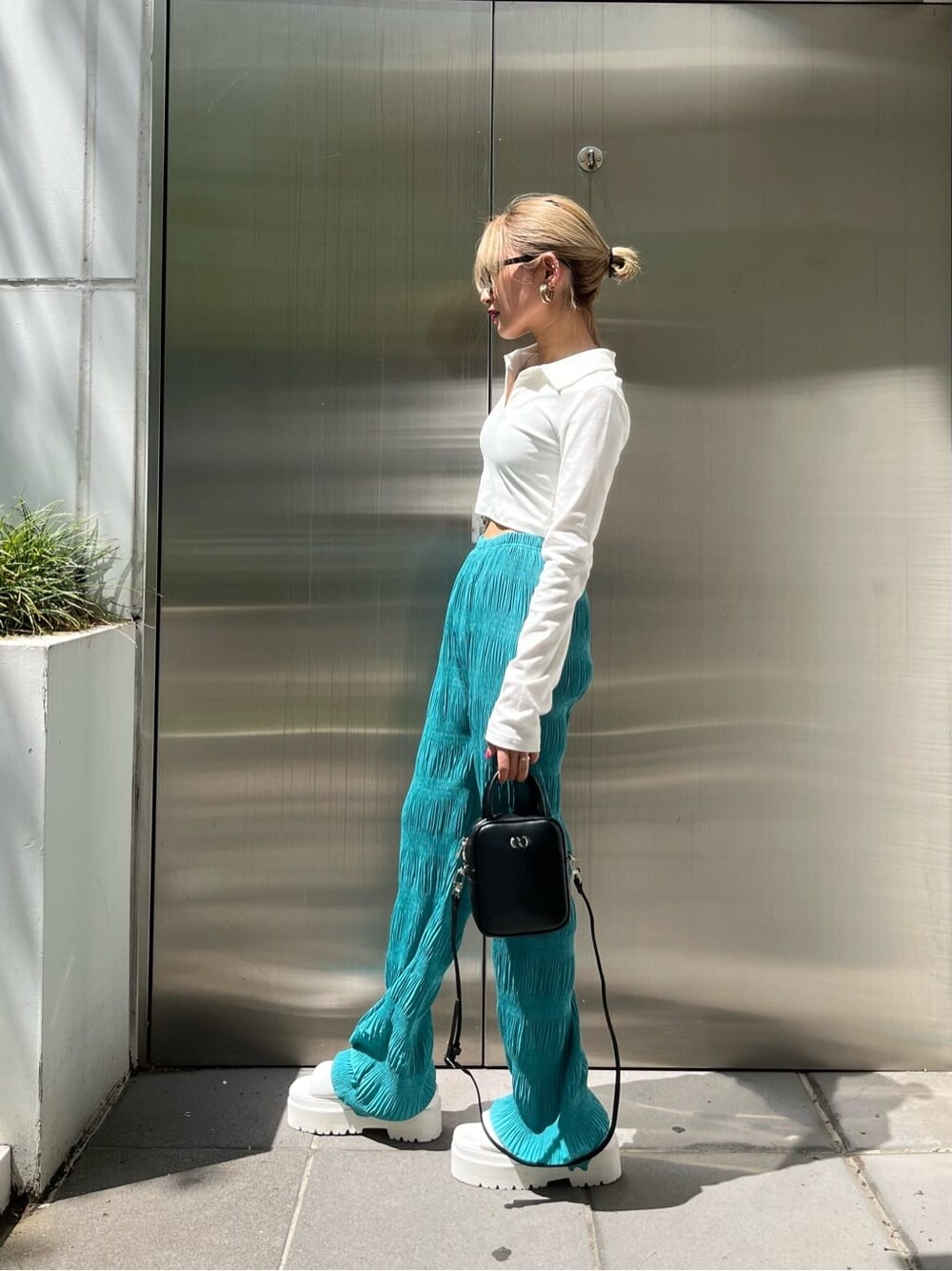 ホワイト系のサンダル、ブラック系のショルダーバッグ、ブルー系のその他パンツを着用したレディースの春コーディネートの2枚目の写真