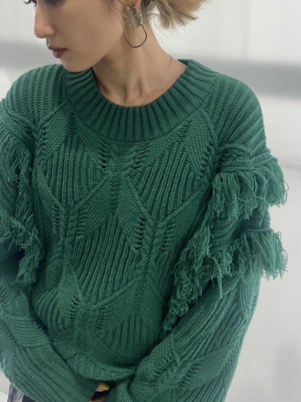 グリーン系のニット/セーター、ブラック系のハンドバッグ、ブラック系のワンピースを着用したレディースの秋コーディネートの4枚目の写真