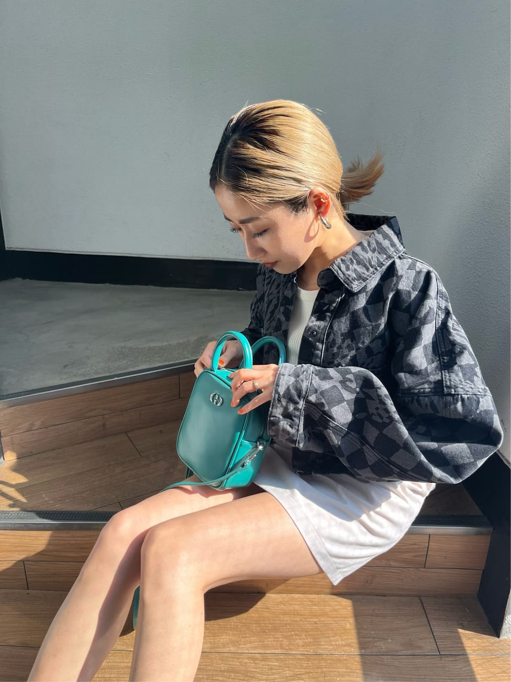 その他のデニムジャケット、ホワイト系のスカート、ブルー系のショルダーバッグを着用したレディースの春コーディネートの6枚目の写真