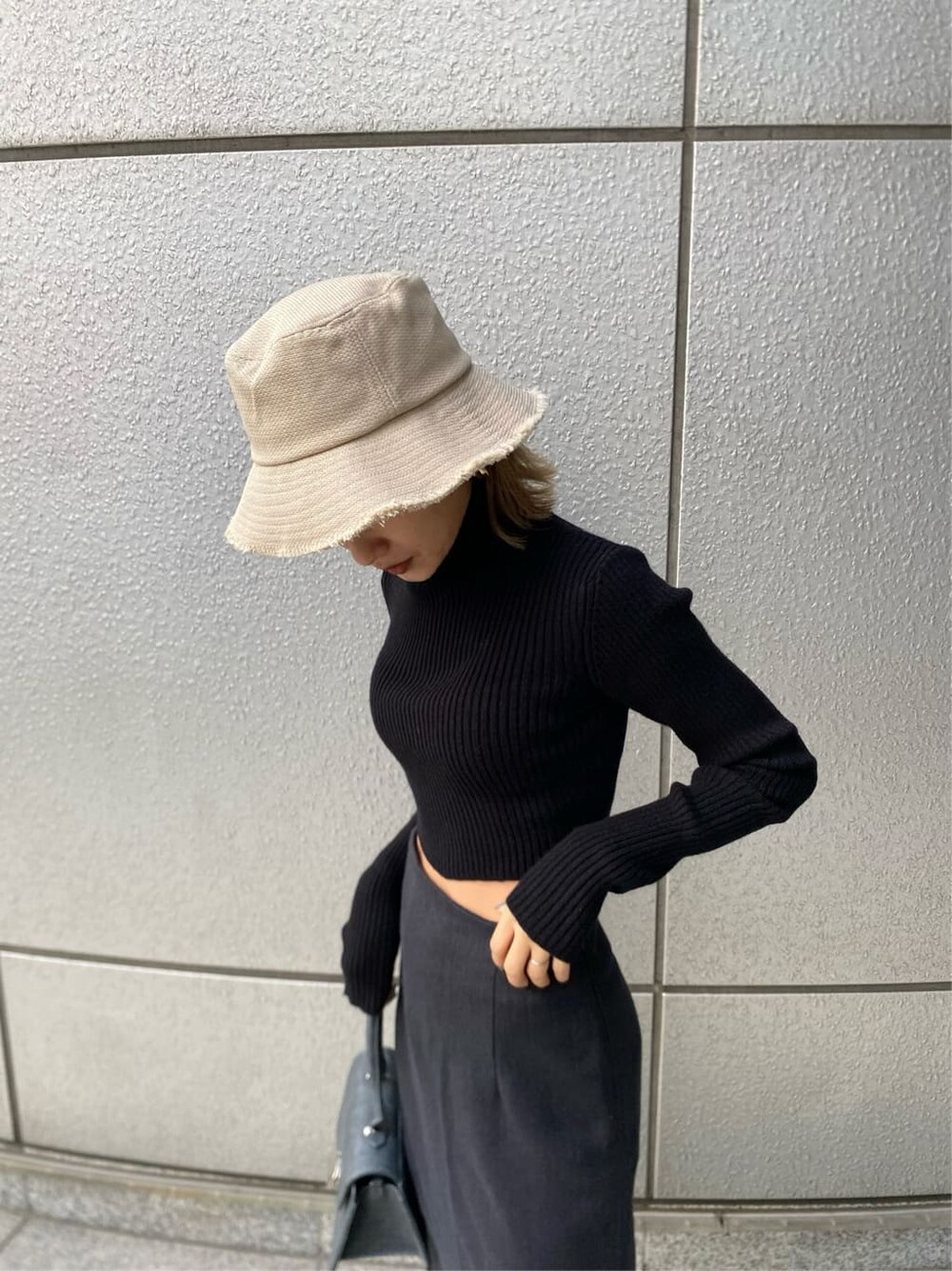 ブラック系のニット/セーター、ブラック系のブーツ、ブラック系のハンドバッグを着用したレディースの冬コーディネートの7枚目の写真