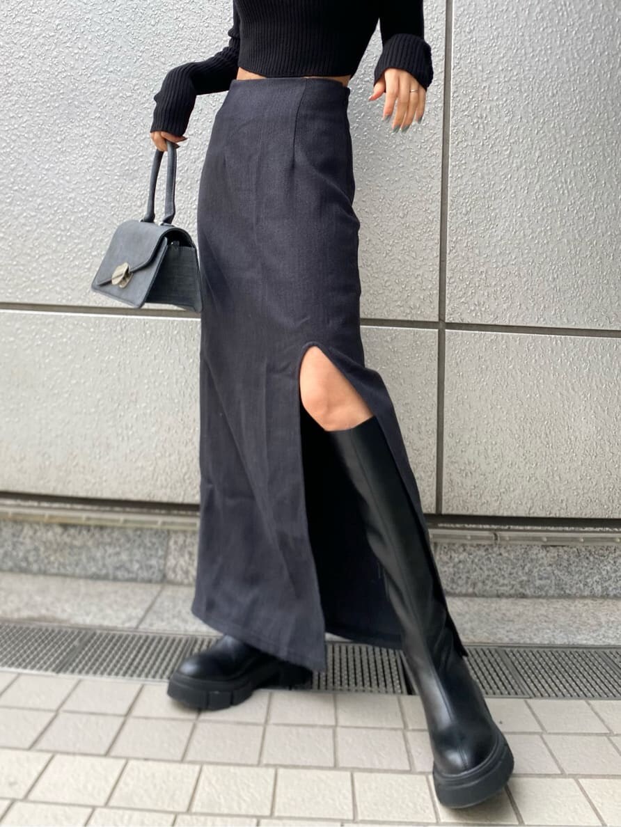 ブラック系のニット/セーター、ブラック系のブーツ、ブラック系のハンドバッグを着用したレディースの冬コーディネートの5枚目の写真