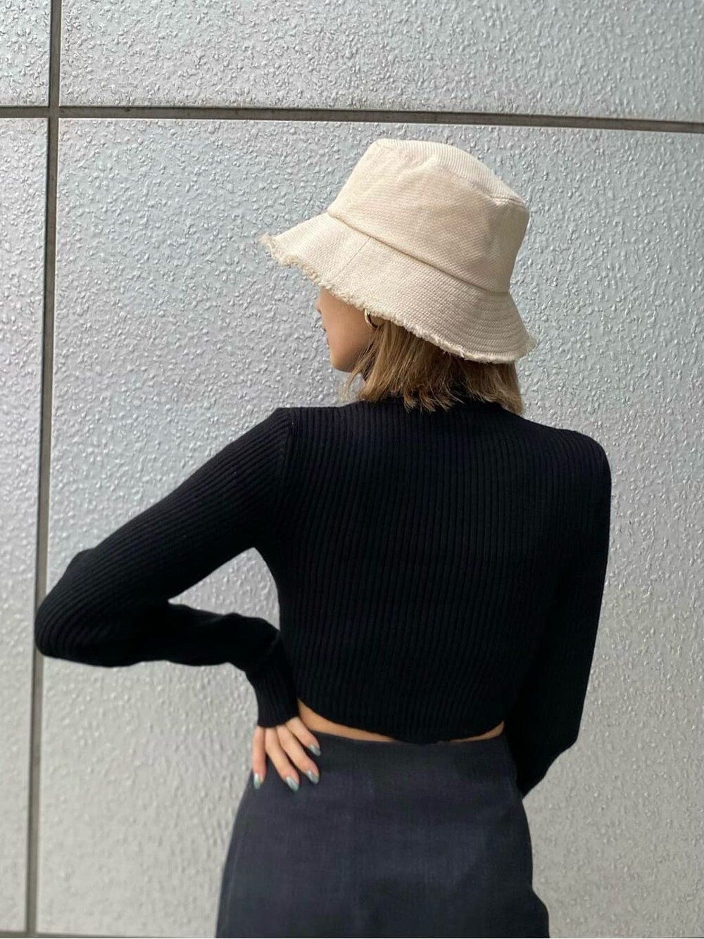 ブラック系のニット/セーター、ブラック系のブーツ、ブラック系のハンドバッグを着用したレディースの冬コーディネートの8枚目の写真