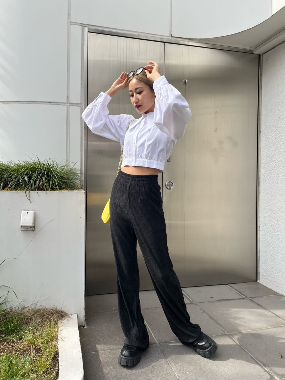 ブラック系のその他パンツ、イエロー系のショルダーバッグ、ホワイト系のシャツ/ブラウスを着用したレディースの春コーディネートの2枚目の写真