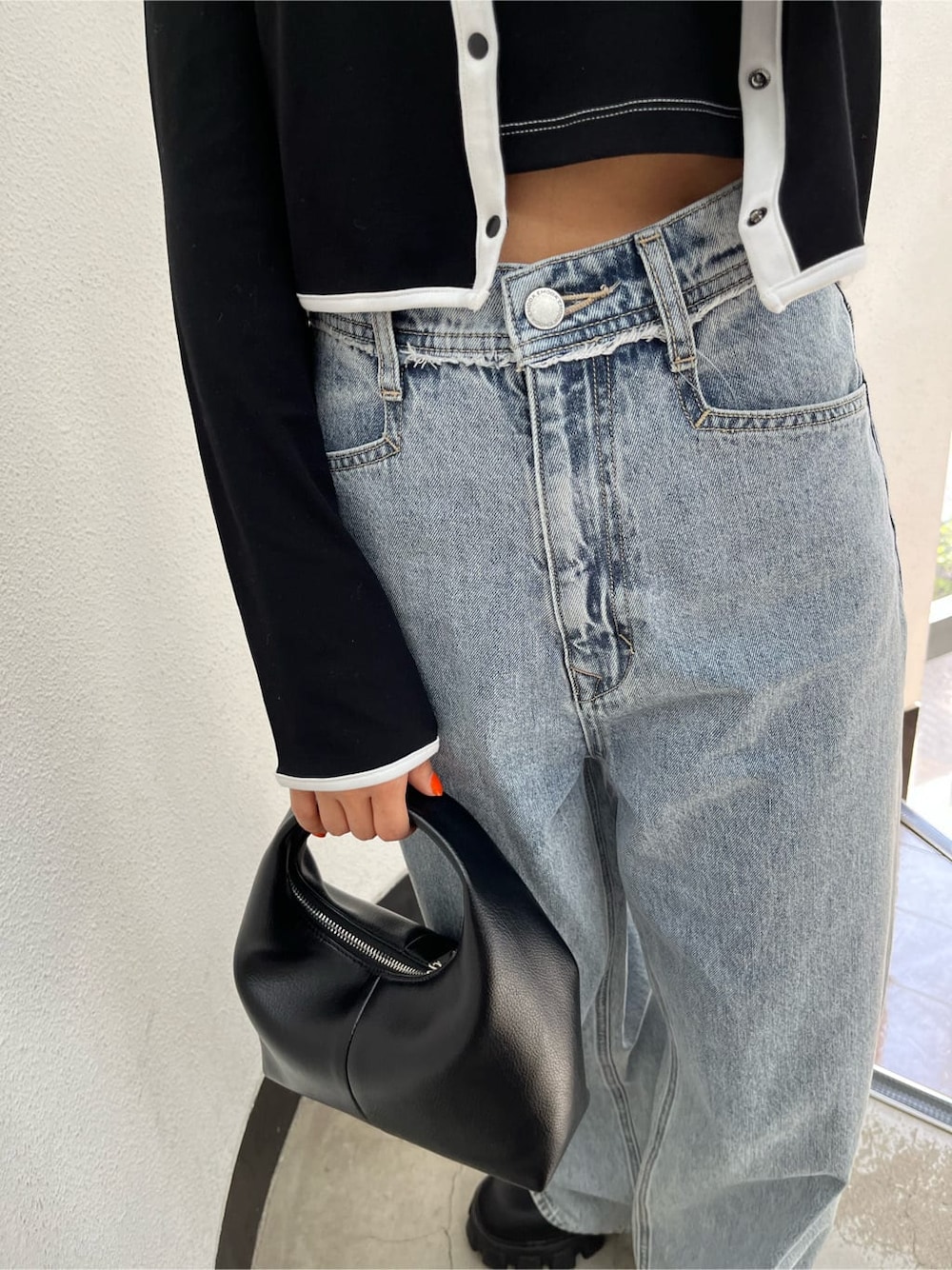 ブラック系のブーツ、ブルー系のデニムパンツ、ブラック系のTシャツ/カットソーを着用したレディースの春コーディネートの9枚目の写真