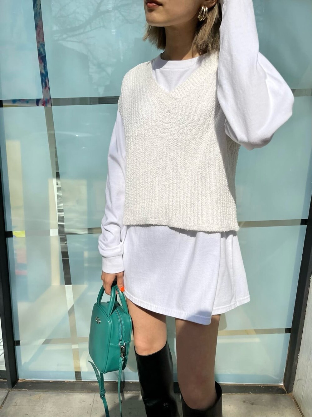 ブラック系のブーツ、ホワイト系のTシャツ/カットソー、ベージュ系のトレンチコートを着用したレディースの春コーディネートの9枚目の写真