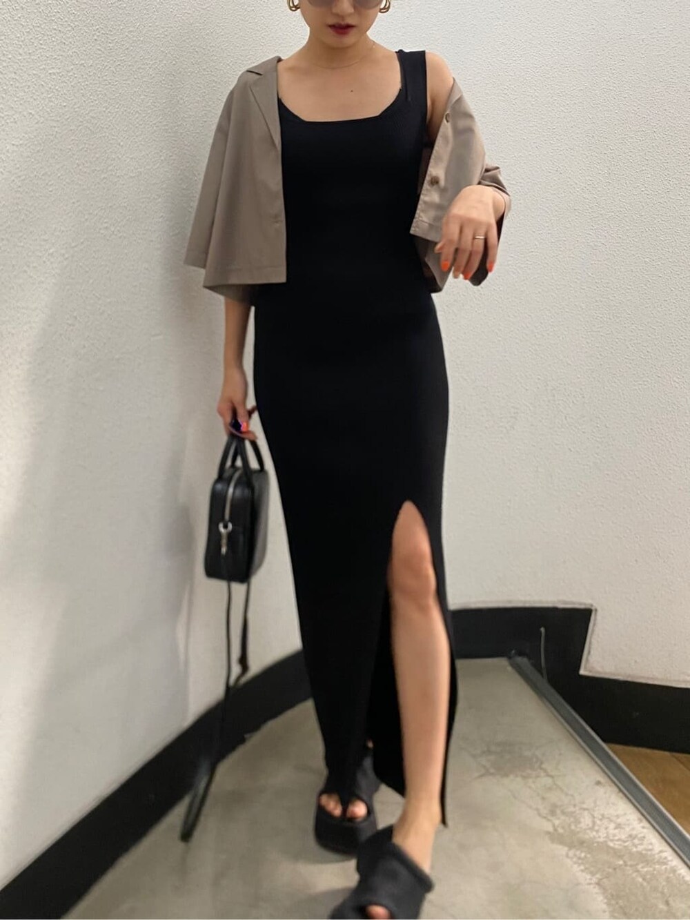 ブラック系のショルダーバッグ、ブラック系のワンピース、ブラック系のサンダルを着用したレディースの春コーディネートの6枚目の写真