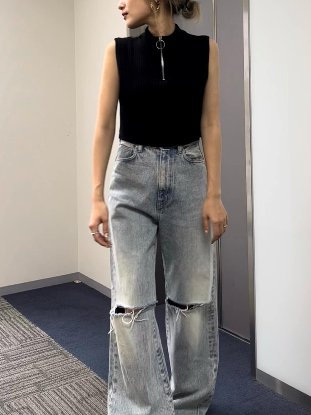 ブラック系のタンクトップ、ブラック系のサンダル、ブルー系のデニムパンツを着用したレディースの夏コーディネートの3枚目の写真