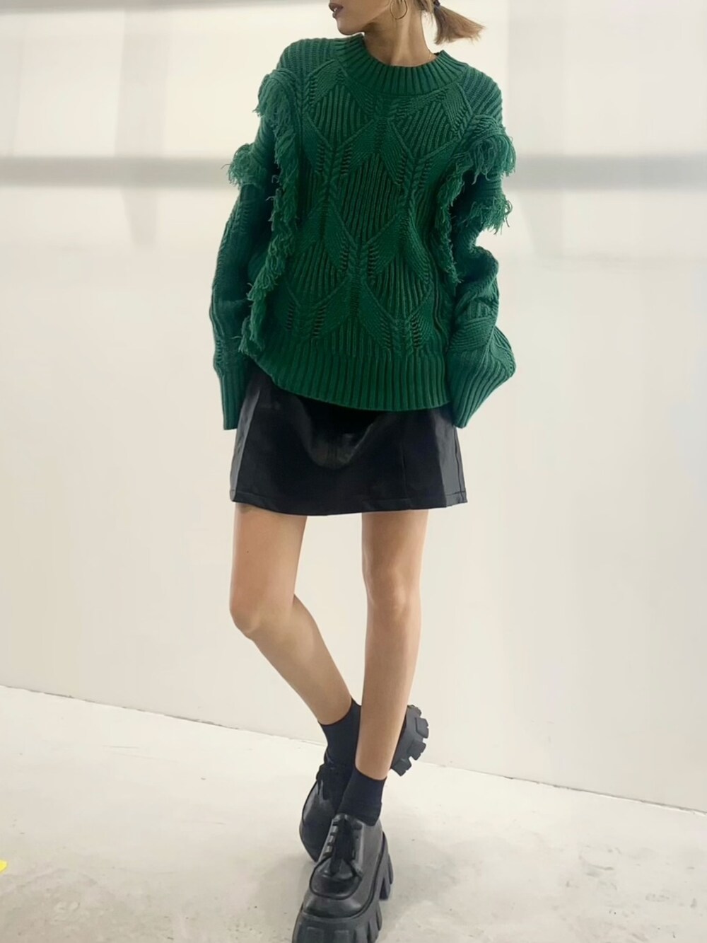 グリーン系のニット/セーター、ブラック系のハンドバッグ、ブラック系のワンピースを着用したレディースの秋コーディネートの3枚目の写真