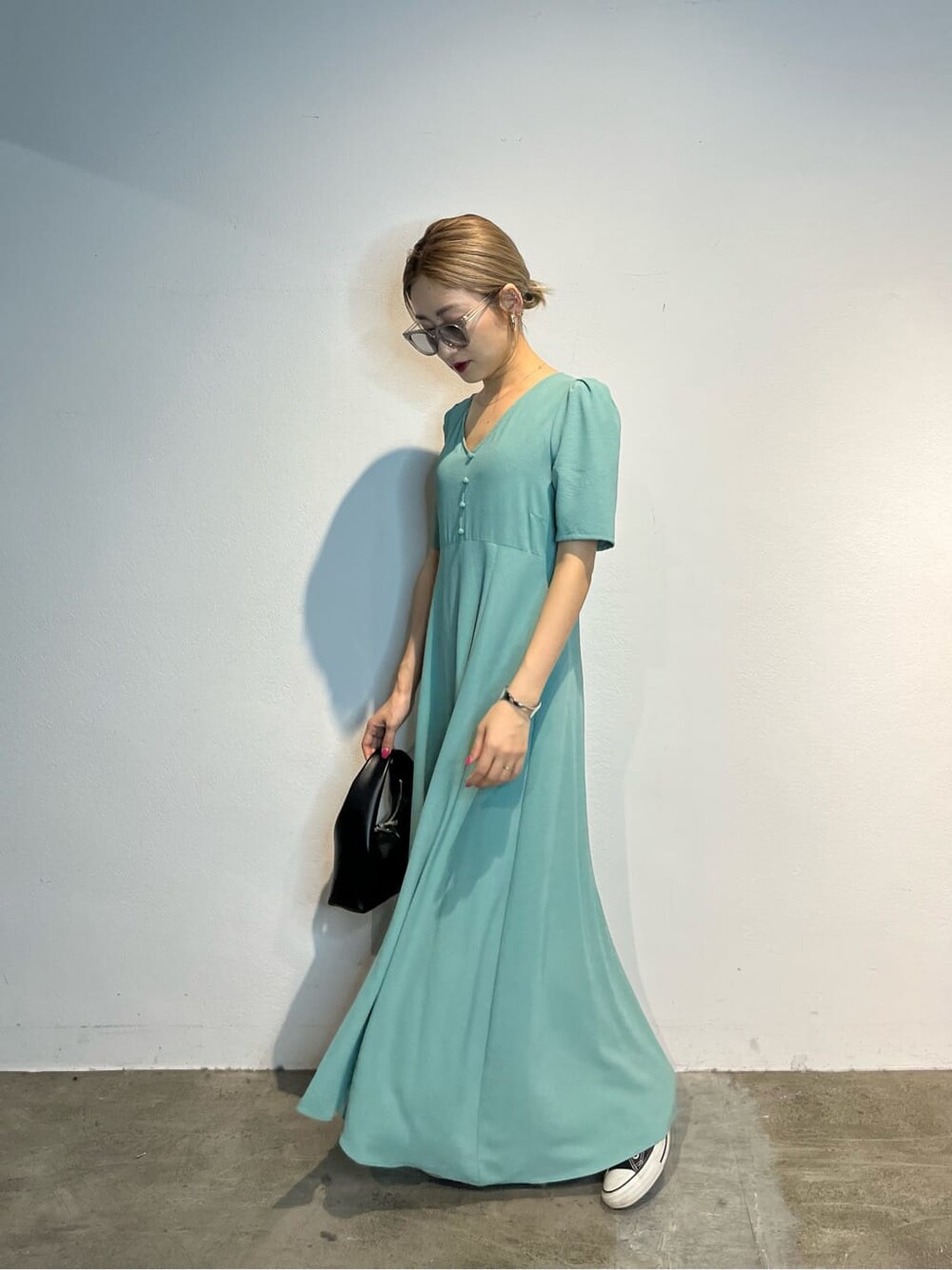 ブルー系のワンピース、ブラック系のハンドバッグを着用したレディースの春コーディネートの3枚目の写真