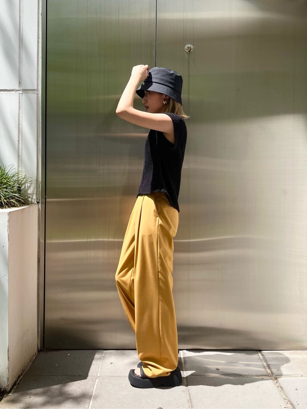 ブラック系のキャミソール、イエロー系のその他パンツ、ブラック系のベストを着用したレディースの春コーディネートの2枚目の写真