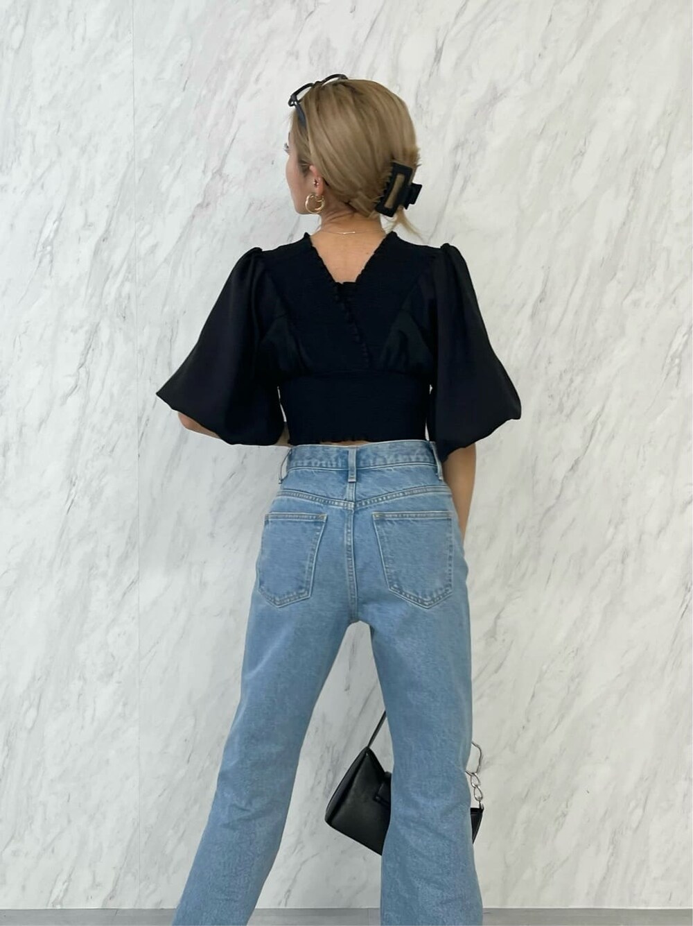 ブラック系のシャツ/ブラウス、ブラック系のハンドバッグ、ブルー系のデニムパンツを着用したレディースの春コーディネートの5枚目の写真