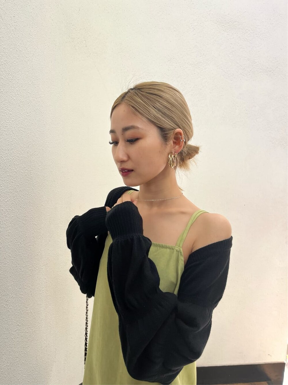 ブラック系のブーツ、ブラック系のニット/セーター、イエロー系のワンピースを着用したレディースの春コーディネートの5枚目の写真