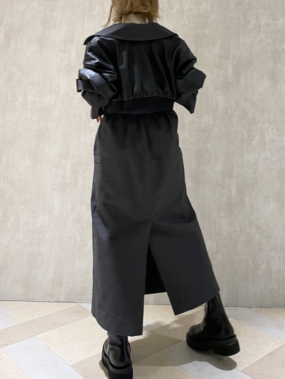 ホワイト系のニット/セーター、グレー系のトレンチコート、ブラック系のブーツを着用したレディースの秋コーディネートの2枚目の写真