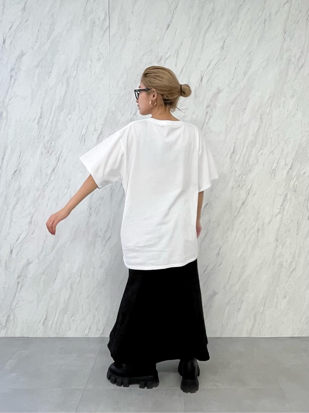 ブラック系のブーツ、ブラック系のスカート、ホワイト系のTシャツ/カットソーを着用したレディースの春コーディネートの6枚目の写真