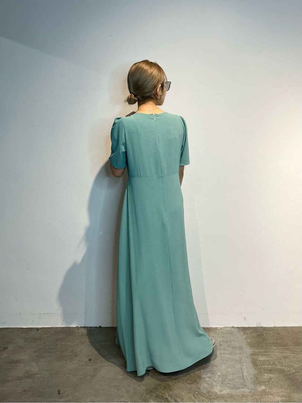 ブルー系のワンピース、ブラック系のハンドバッグを着用したレディースの春コーディネートの4枚目の写真