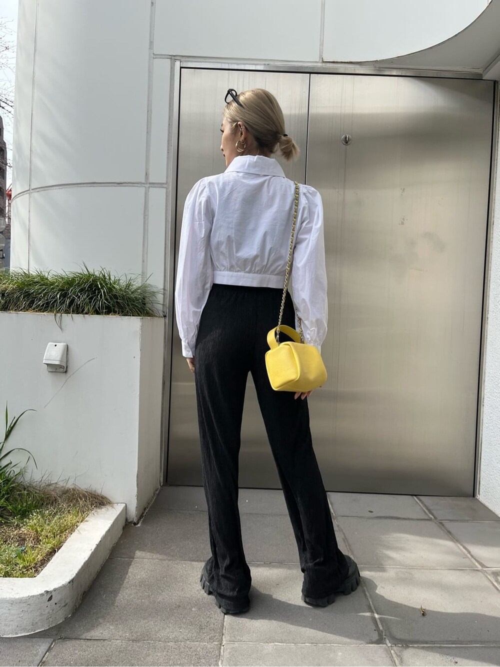 ブラック系のその他パンツ、イエロー系のショルダーバッグ、ホワイト系のシャツ/ブラウスを着用したレディースの春コーディネートの4枚目の写真