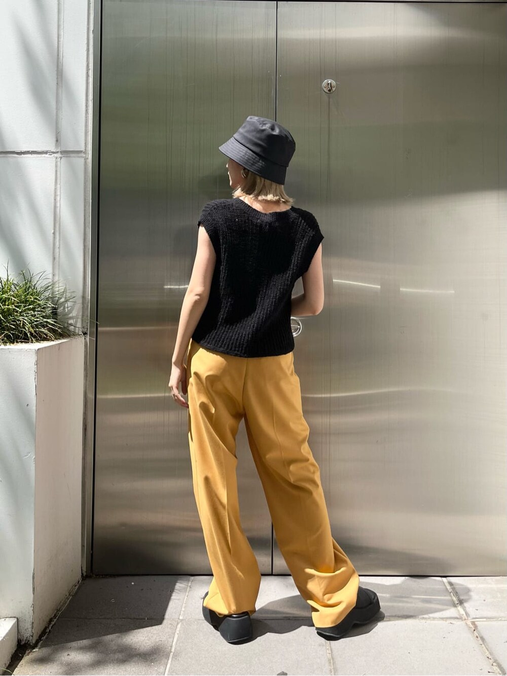 ブラック系のキャミソール、イエロー系のその他パンツ、ブラック系のベストを着用したレディースの春コーディネートの5枚目の写真