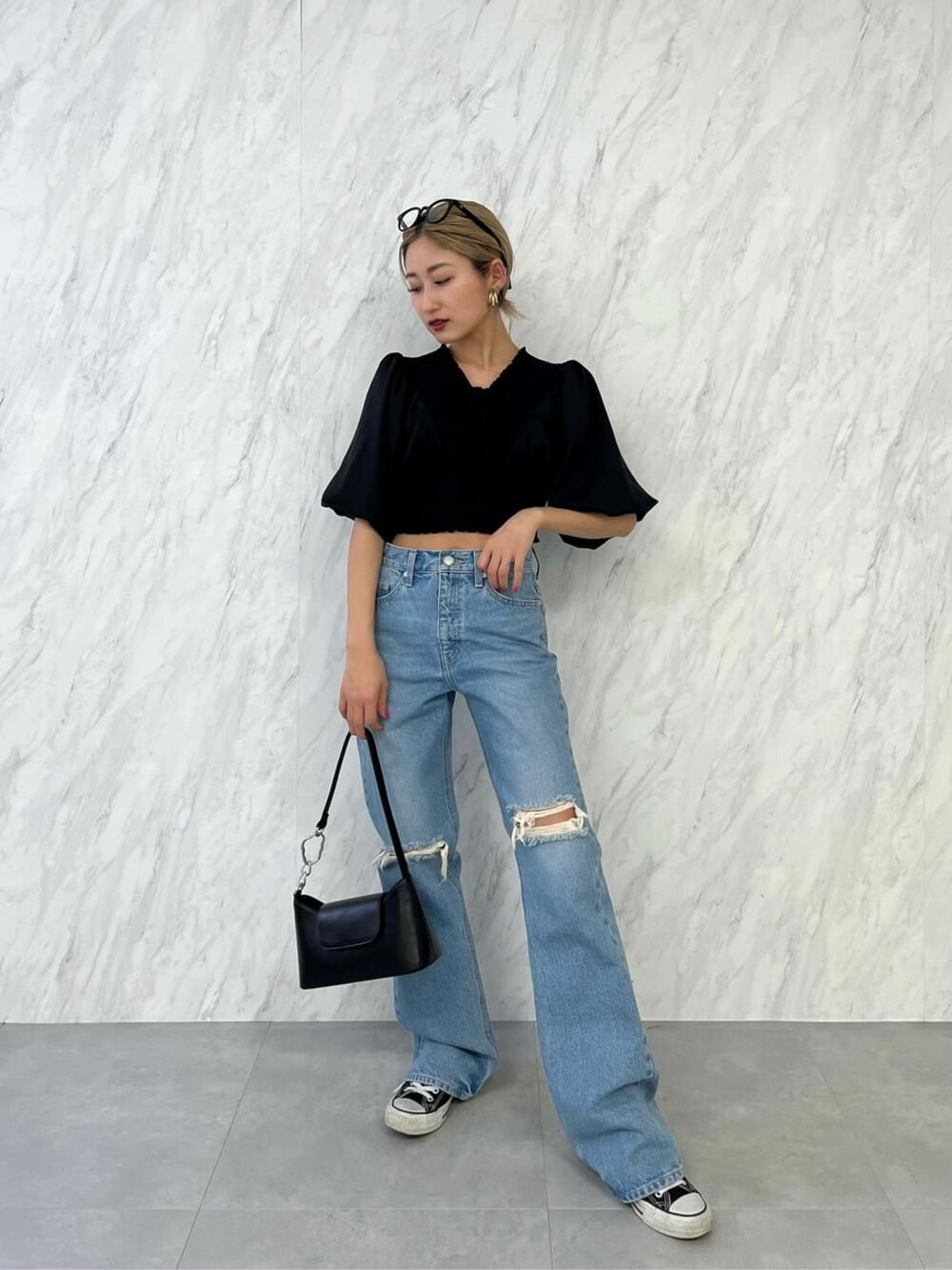 ブラック系のシャツ/ブラウス、ブラック系のハンドバッグ、ブルー系のデニムパンツを着用したレディースの春コーディネートの2枚目の写真