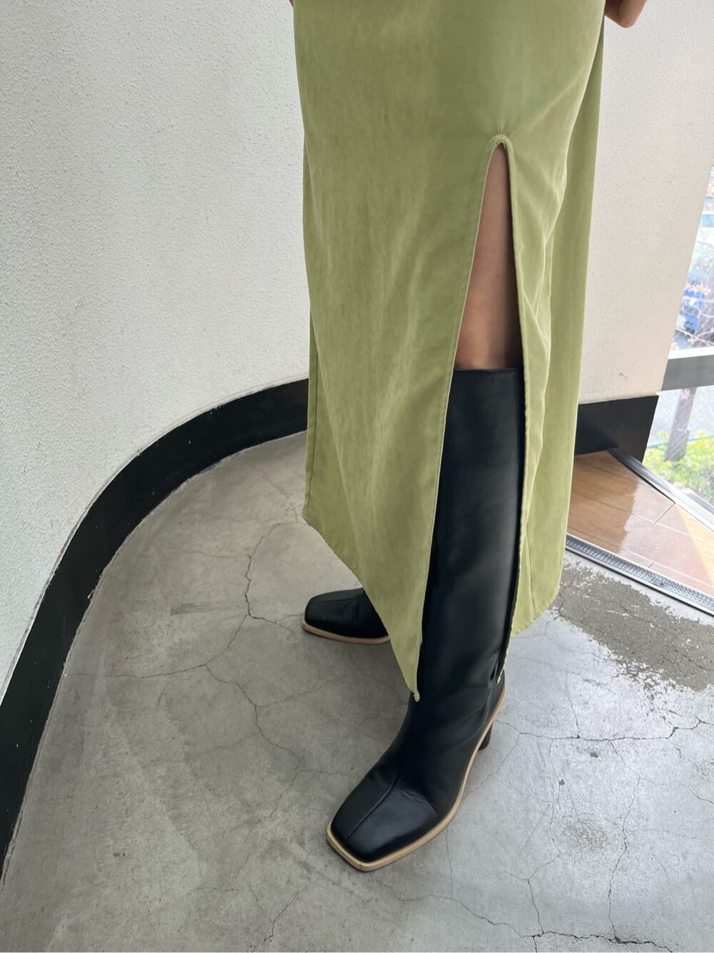 ブラック系のブーツ、ブラック系のニット/セーター、イエロー系のワンピースを着用したレディースの春コーディネートの7枚目の写真