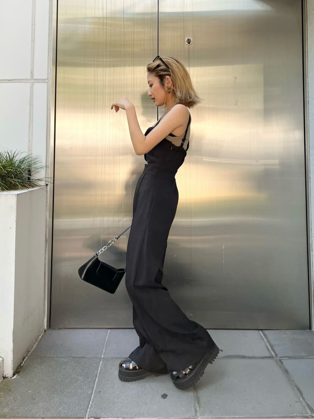 ブラック系のつなぎ/オールインワン、ベージュ系のタンクトップ、ブラック系のハンドバッグを着用したレディースの夏コーディネートの2枚目の写真