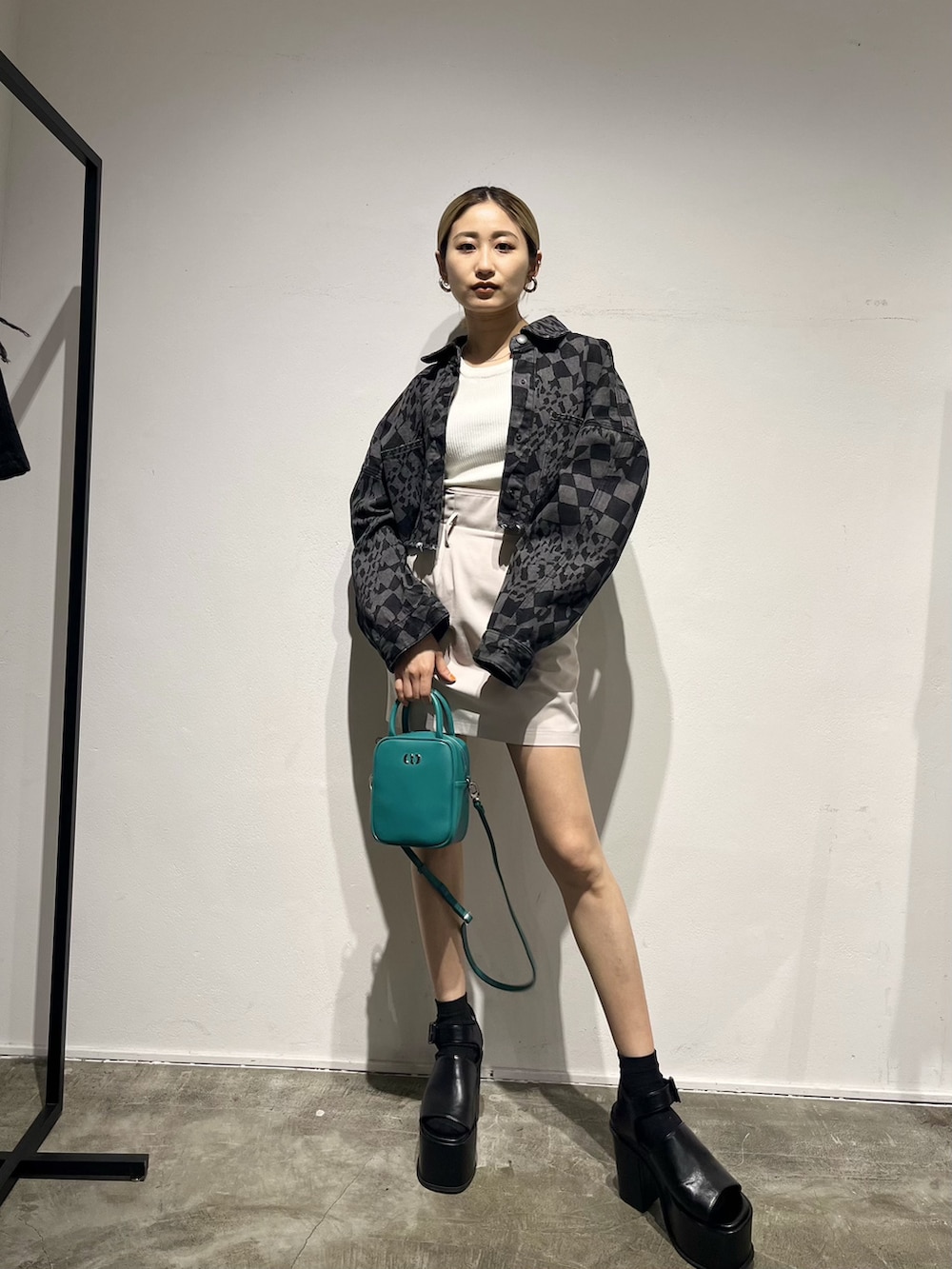 その他のデニムジャケット、ホワイト系のスカート、ブルー系のショルダーバッグを着用したレディースの春コーディネートの2枚目の写真