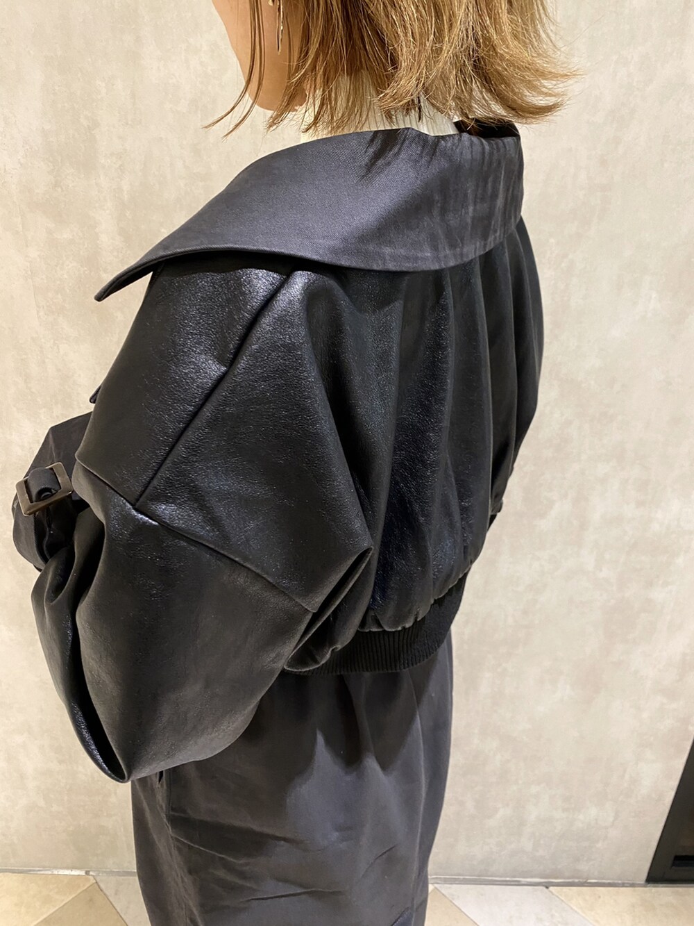 ホワイト系のニット/セーター、グレー系のトレンチコート、ブラック系のブーツを着用したレディースの秋コーディネートの5枚目の写真