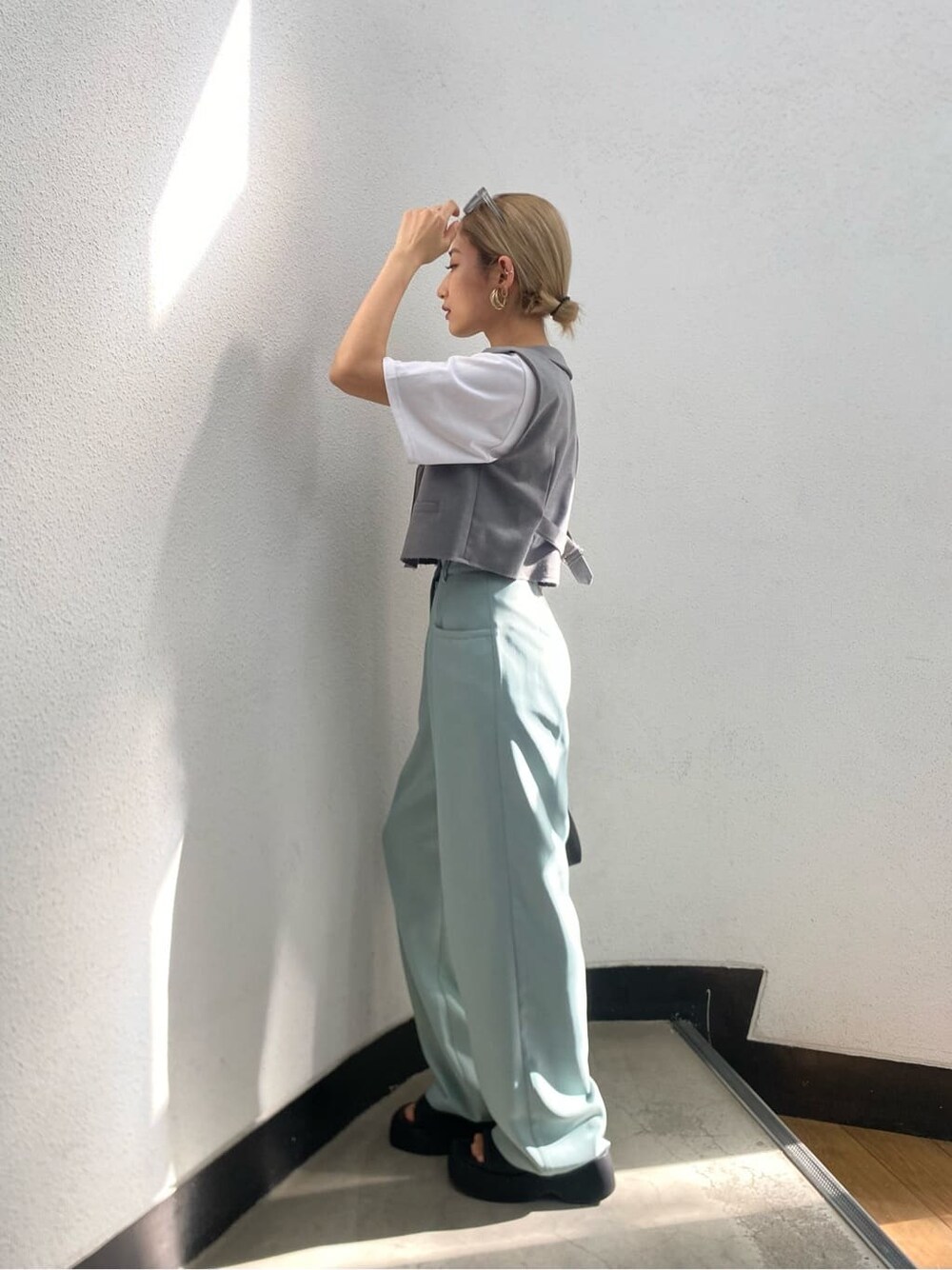 ホワイト系のTシャツ/カットソー、ブラック系のサンダル、グレー系のテーラードジャケットを着用したレディースの春コーディネートの4枚目の写真