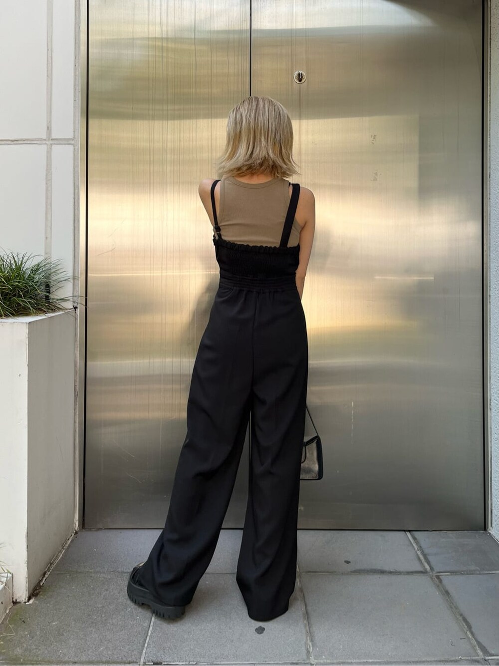 ブラック系のつなぎ/オールインワン、ベージュ系のタンクトップ、ブラック系のハンドバッグを着用したレディースの夏コーディネートの3枚目の写真
