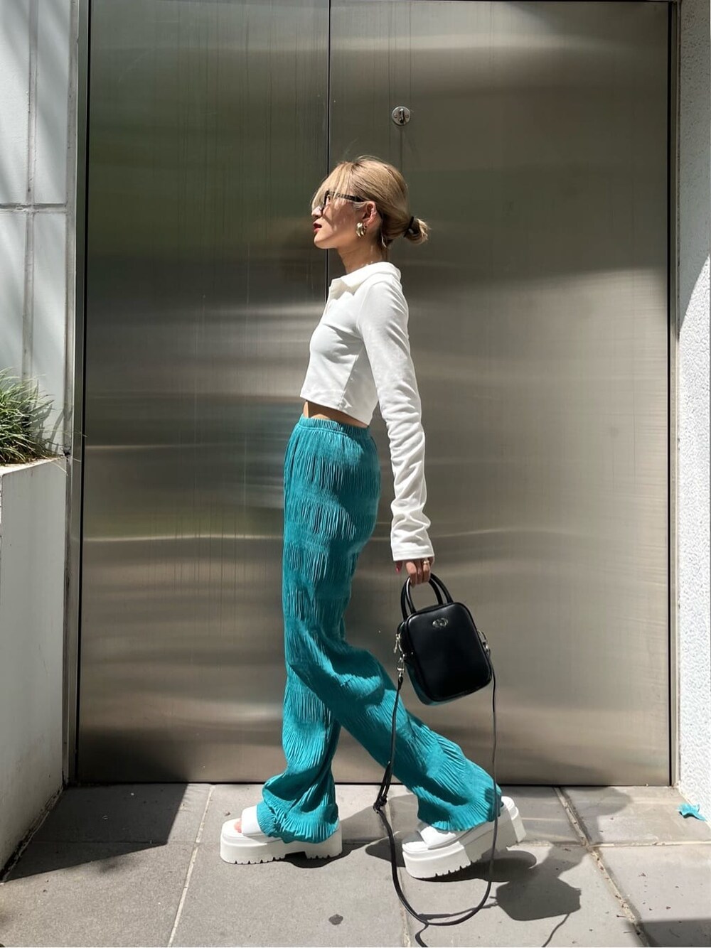 ホワイト系のサンダル、ブラック系のショルダーバッグ、ブルー系のその他パンツを着用したレディースの春コーディネートの3枚目の写真