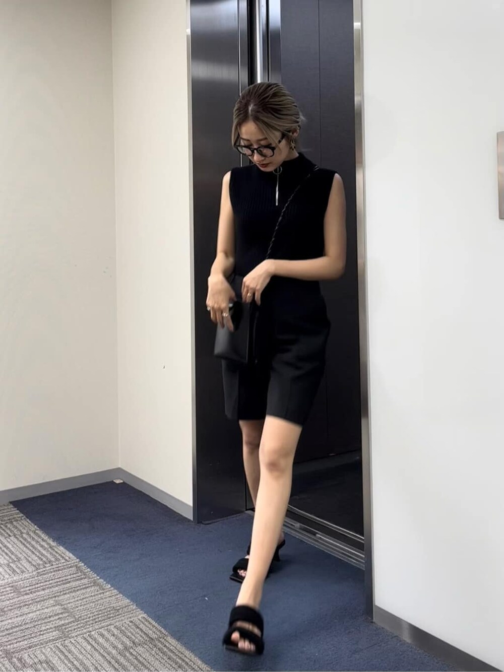 ブラック系のサンダル、ブラック系のタンクトップを着用したレディースの夏コーディネートの2枚目の写真