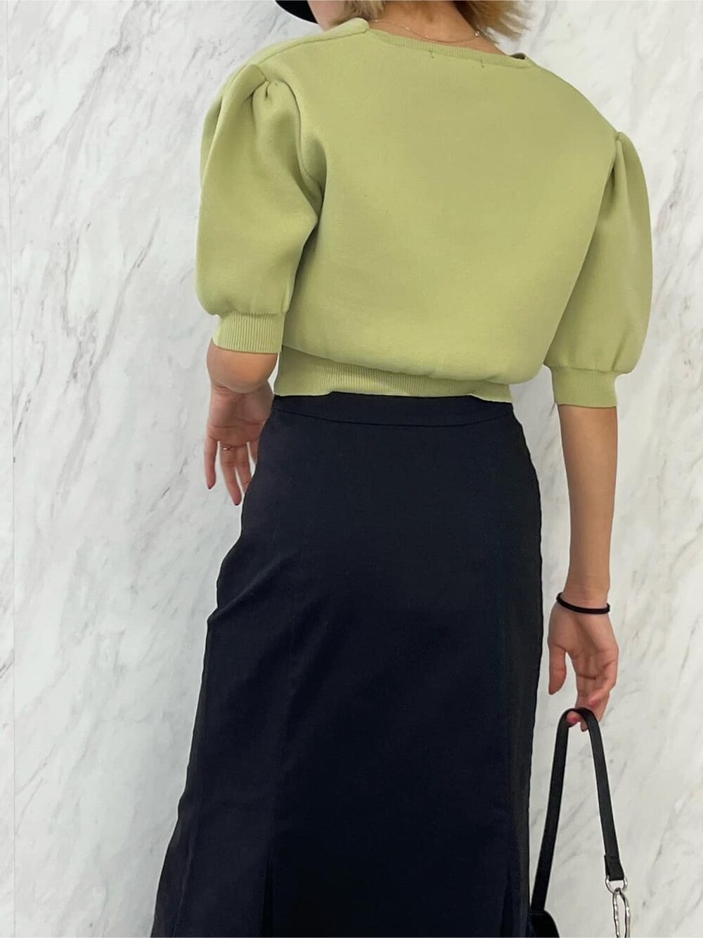 ブラック系のブーツ、ブラック系のスカート、イエロー系のニット/セーターを着用したレディースの春コーディネートの6枚目の写真