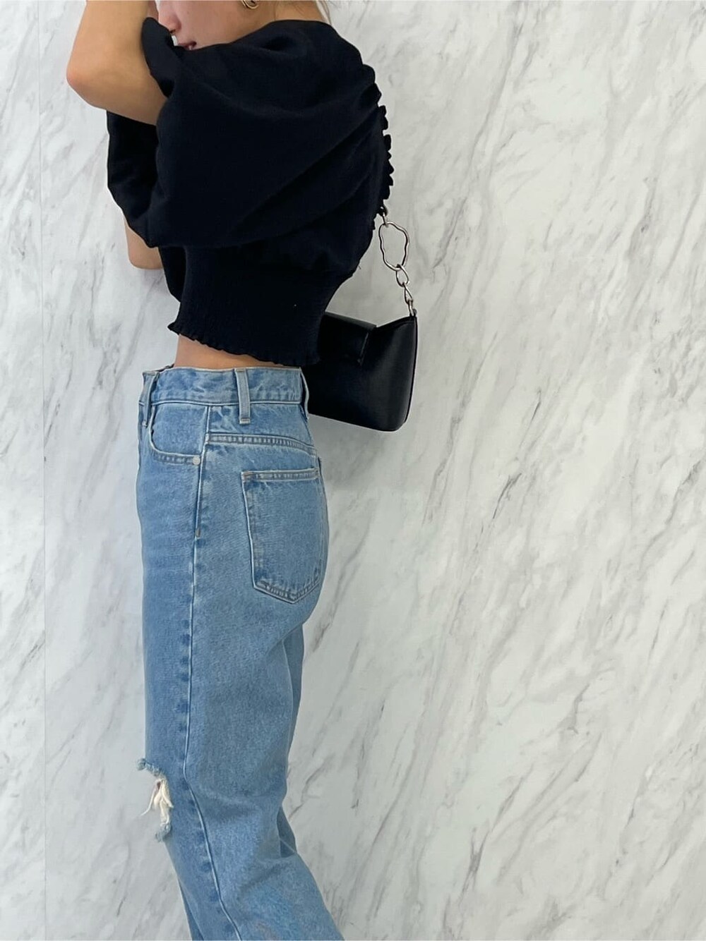 ブラック系のシャツ/ブラウス、ブラック系のハンドバッグ、ブルー系のデニムパンツを着用したレディースの春コーディネートの7枚目の写真