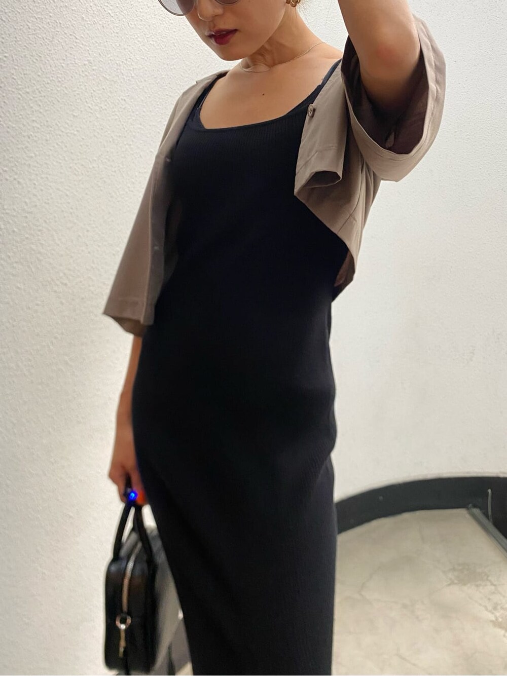 ブラック系のショルダーバッグ、ブラック系のワンピース、ブラック系のサンダルを着用したレディースの春コーディネートの7枚目の写真