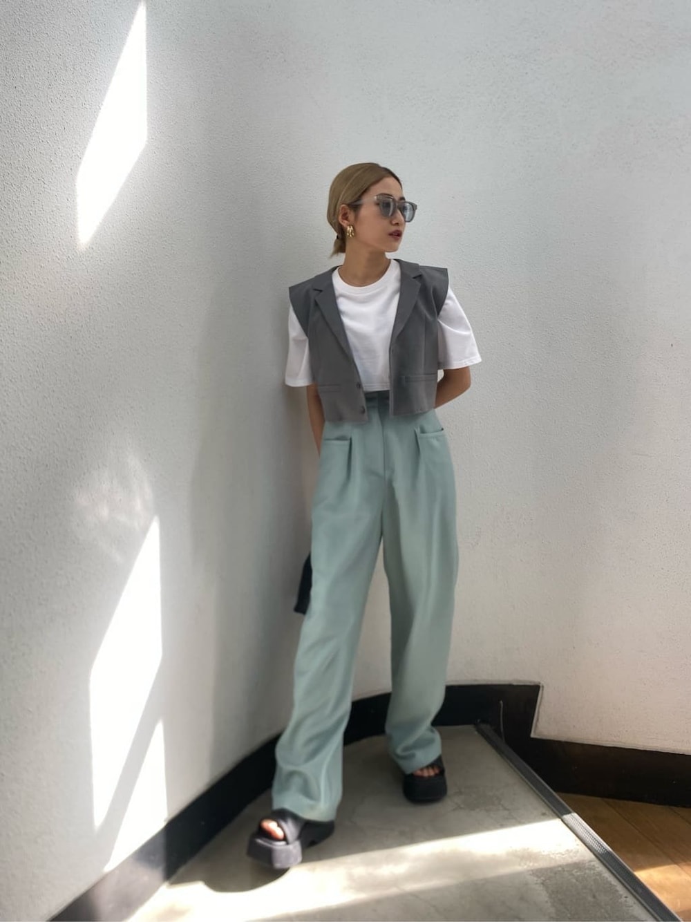 ホワイト系のTシャツ/カットソー、ブラック系のサンダル、グレー系のテーラードジャケットを着用したレディースの春コーディネートの3枚目の写真