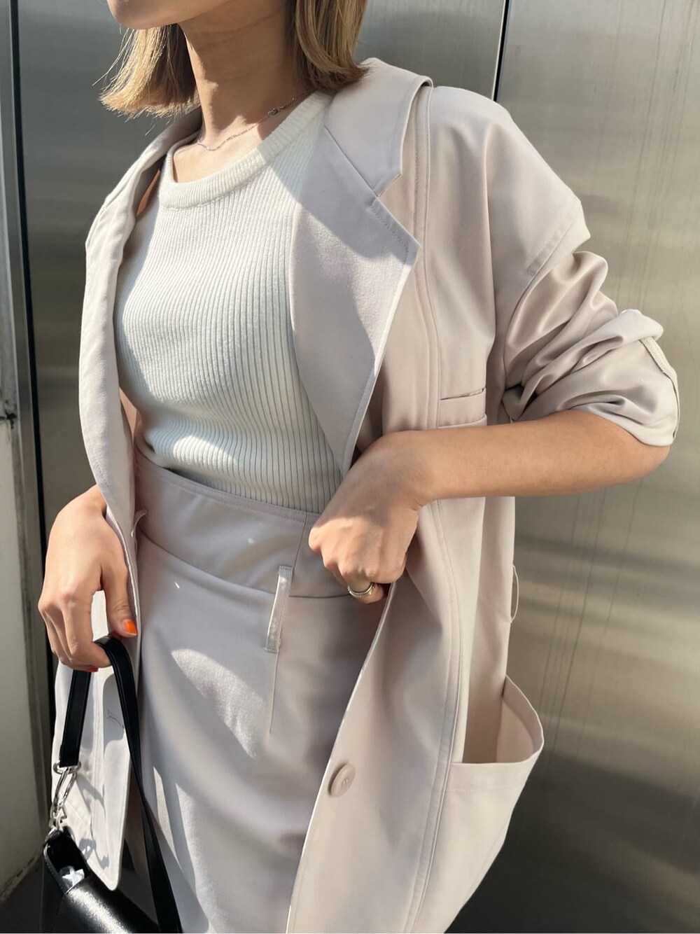 ホワイト系のテーラードジャケット、ホワイト系のスカートを着用したレディースの春コーディネートの5枚目の写真