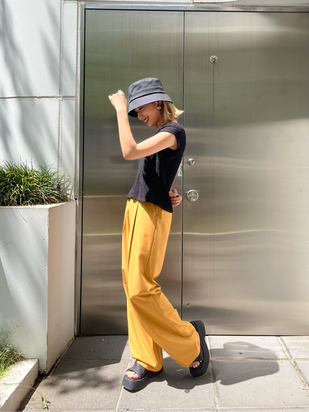 ブラック系のキャミソール、イエロー系のその他パンツ、ブラック系のベストを着用したレディースの春コーディネートの4枚目の写真