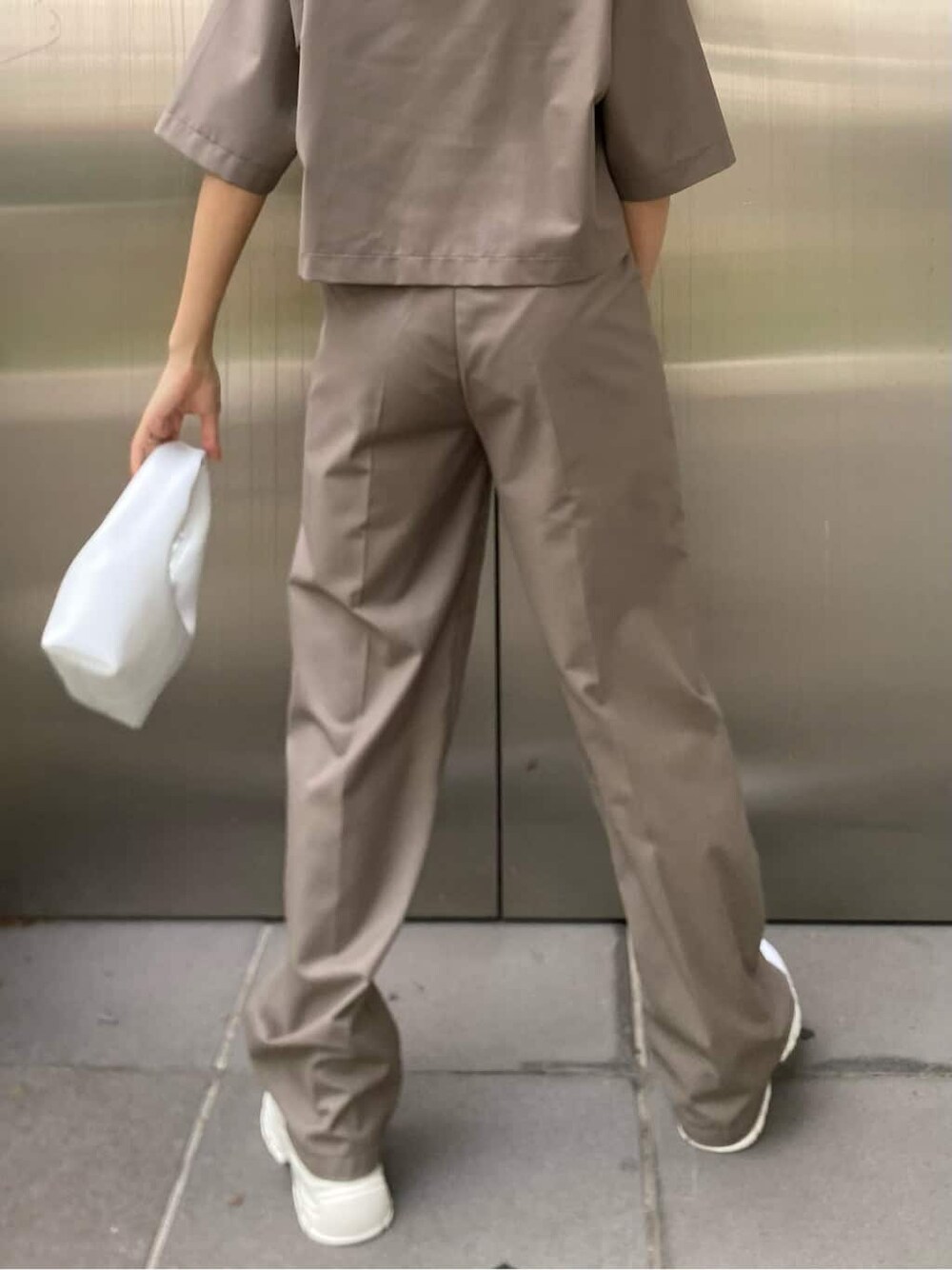 ホワイト系のスニーカー、ブラック系のハンドバッグを着用したレディースの春コーディネートの5枚目の写真