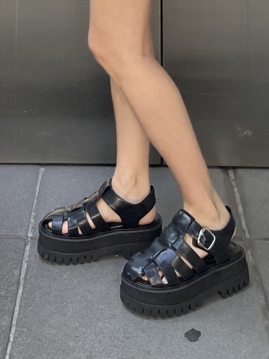 ブラック系のハンドバッグ、ベージュ系のタンクトップ、ブラック系のその他パンツを着用したレディースの夏コーディネートの6枚目の写真