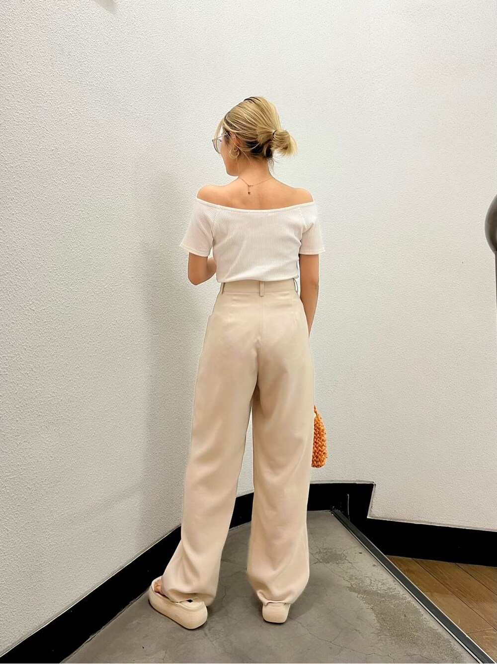 ホワイト系のサンダル、ホワイト系のTシャツ/カットソー、オレンジ系のハンドバッグを着用したレディースの夏コーディネートの3枚目の写真