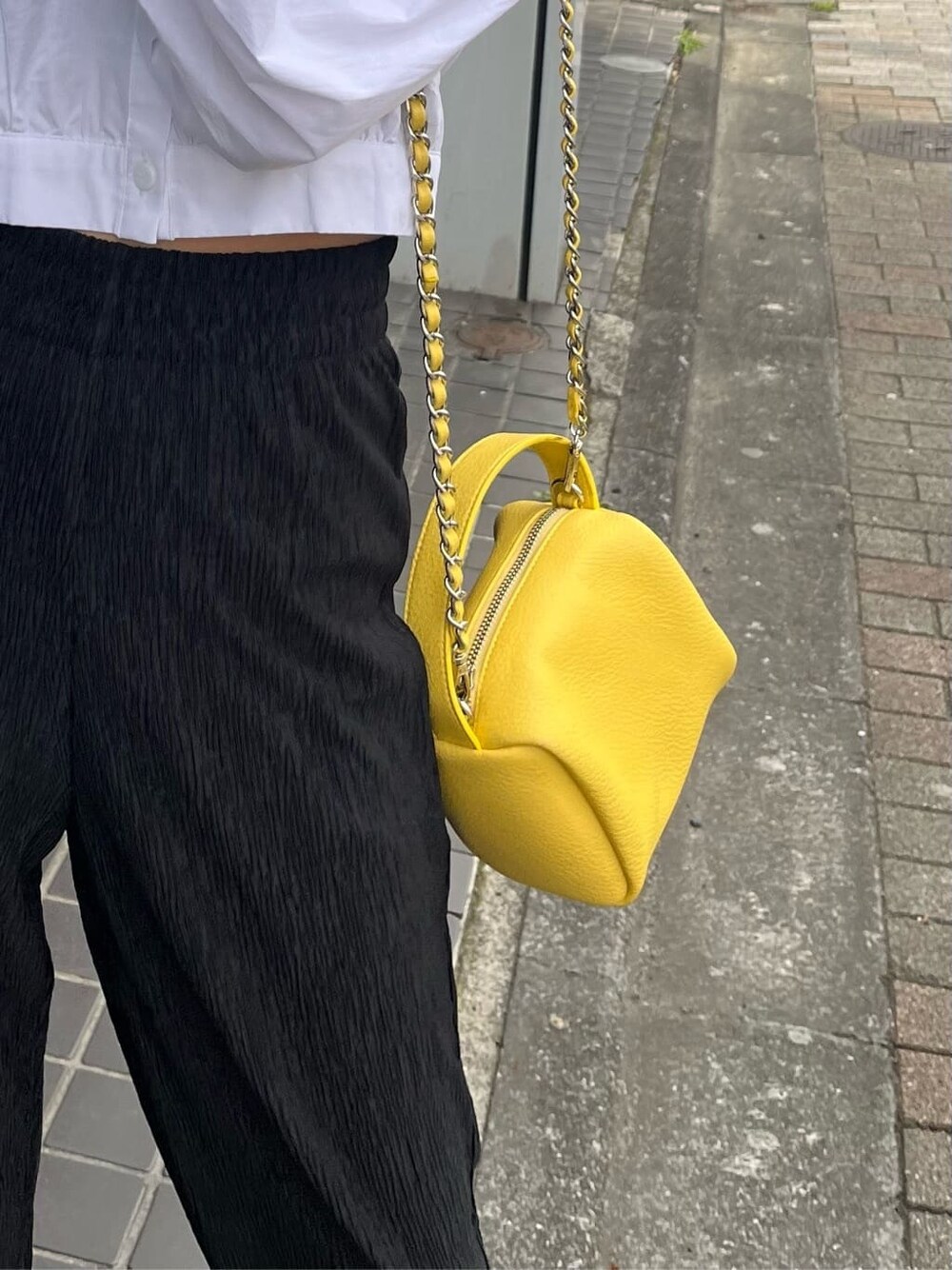 ブラック系のその他パンツ、イエロー系のショルダーバッグ、ホワイト系のシャツ/ブラウスを着用したレディースの春コーディネートの8枚目の写真